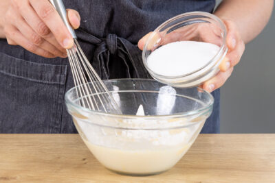 Puddingpulver und Zucker zur Hafermilch geben