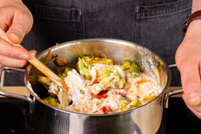 veganes Thai-Curry mit Kokosmilch aufgießen