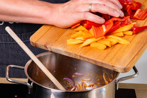 Karotten und Paprika in Topf geben