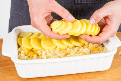 Sauerkraut und Kartoffeln in eine Auflaufform schichten