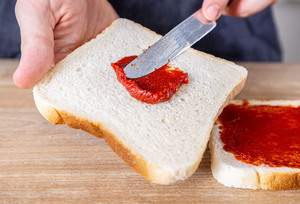 Toast mit Tomatenmark bestreichen