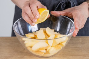 Saft einer Zitrone über die Äpfel geben