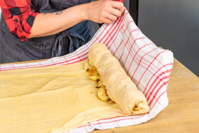 Apfelstrudel auf Küchentuch rollen