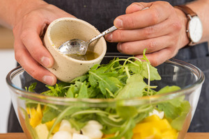Dressing über den Avocado-Mango-Salat geben