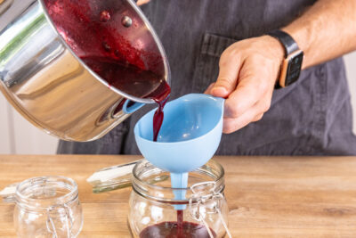 Brombeermarmelade ohne Kerne in Gläser füllen