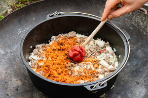 Gewürzmischung und Tomatenmark zum Chili geben