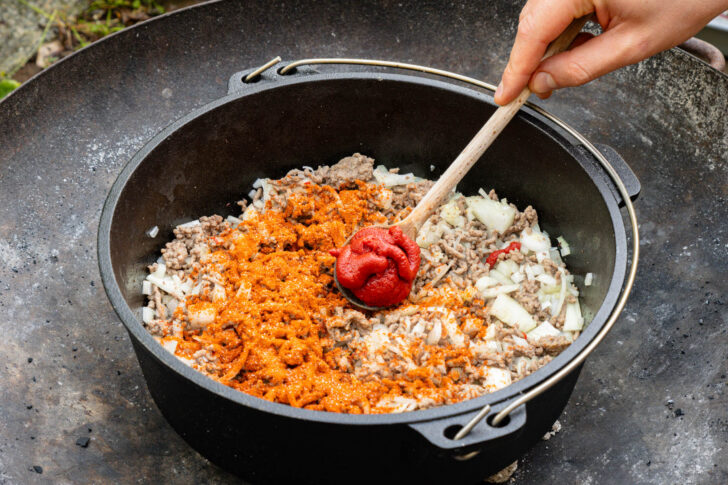 Gewürzmischung und Tomatenmark zum Chili geben