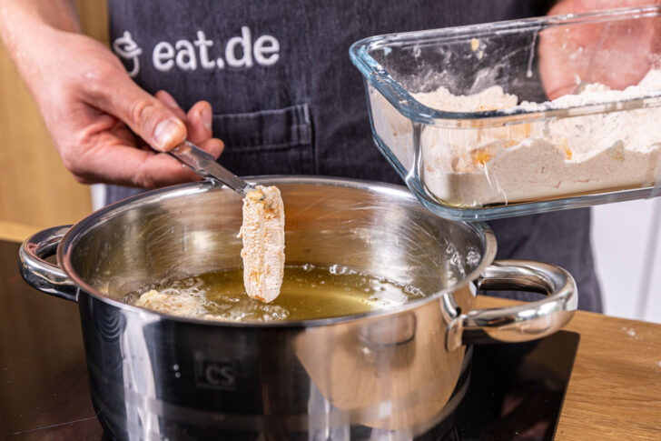 Tintenfischringe in das heiße Fett geben