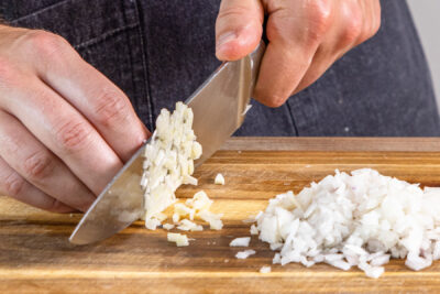 Knoblauch und Zwiebel würfeln
