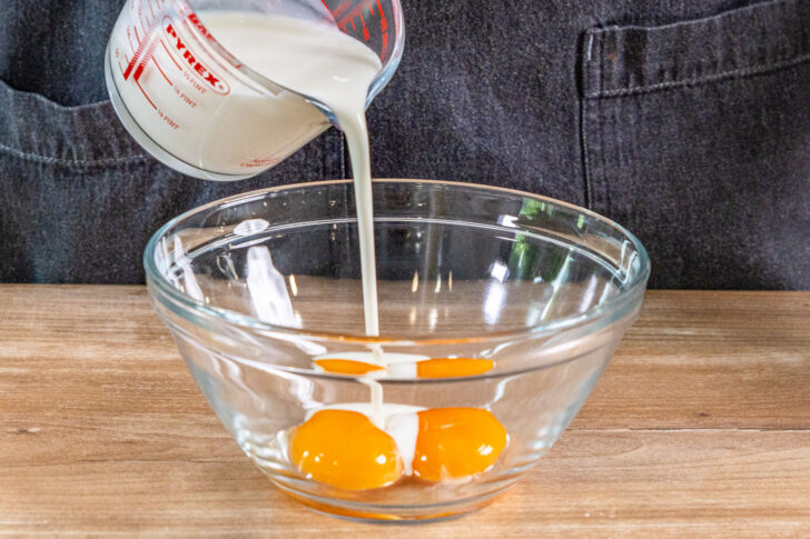 Milch zu den Eiern gießen