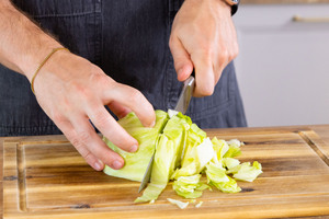 Salat in dünne Streifen schneiden.