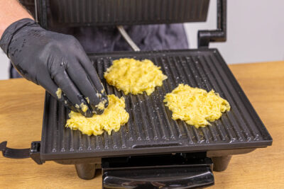 Kartoffelpuffermasse in den Kontaktgrill geben