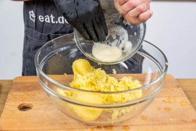Speisestärke unter die Kartoffeln rühren