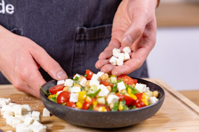 Feta auf Kichererbsensalat verteilen