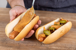 Sauce auf den Hot Dog geben
