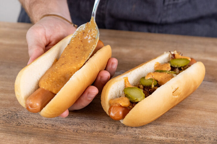 Sauce auf den Hot Dog geben