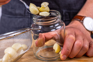 Knoblauch in ein Glas geben