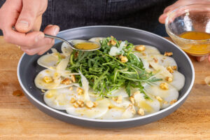Dressing über das Kohlrabi-Carpaccio geben
