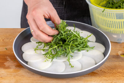 Rucola auf den Kohlrabi geben