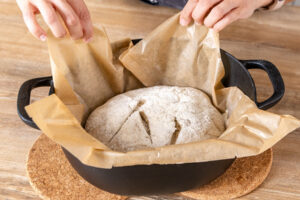 Krustenbrot in den heißen Topf heben