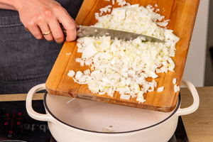 Zwiebelwürfel in Bräter geben