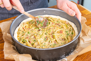 Zwiebel-Masse auf Hefeteig verteilen