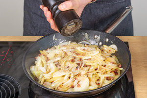 Zwiebeln und Speckwürfel mit Pfeffer würzen