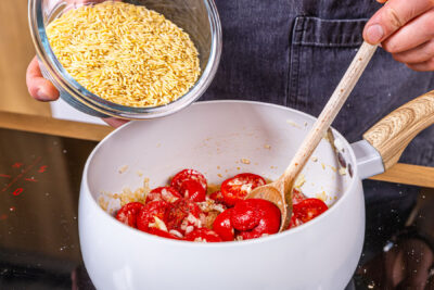 Orzo Pasta in den Topf geben