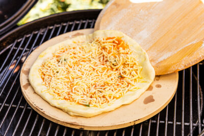 Pizza auf den Pizzastein im Grill legen und backen