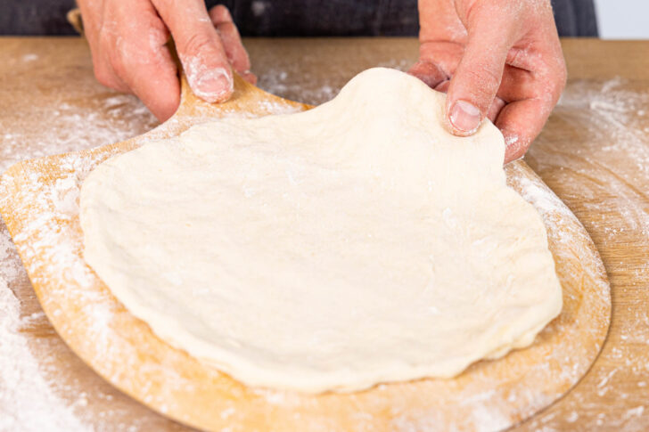 Pizzaboden auf den bemehlten Pizzaspatel legen