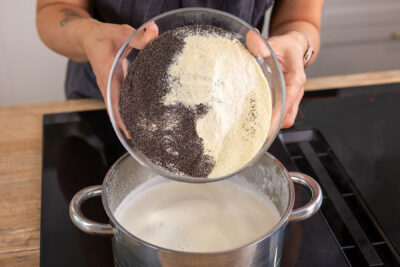 Mohn und Grieß zur Milch in den Topf geben