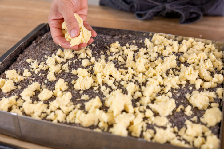Streusel über dem Mohnkuchen verteilen