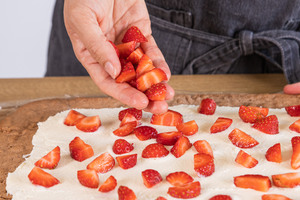 Erdbeeren auf der Creme verteilen