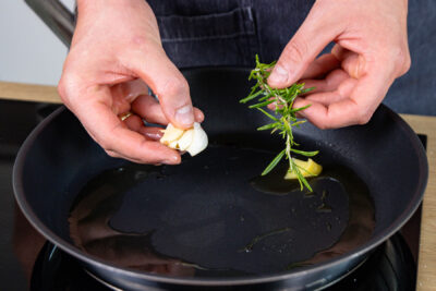 Knoblauch und Rosmarin mit Butterschmalz in Pfanne geben