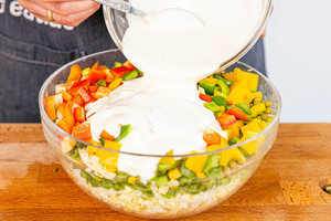 Dressing über den Salat geben