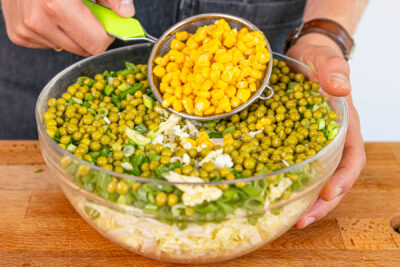 Mais und Erbsen abgeißen und auf Salat verteilen