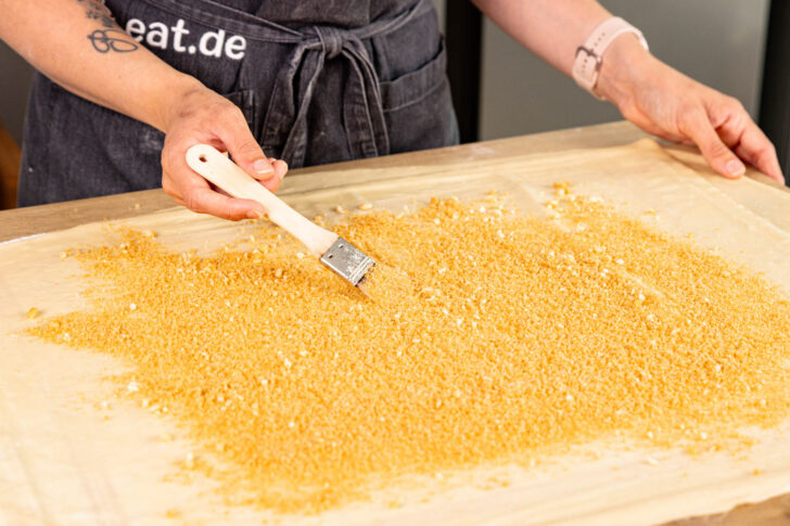 geröstete Semmelbrösel auf dem Teig verteilen