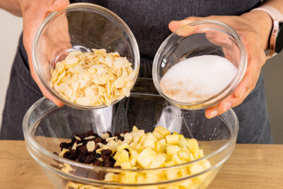 Mandeln, Rosinen sowie Äpfel mit Zucker und Zimt vermengen