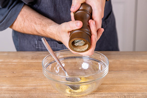 Dressing mit Pfeffer würzen
