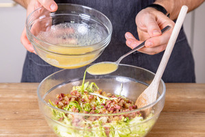 Dressing über den bayrischen Krautsalat geben