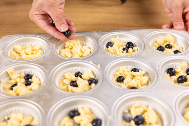 Blaubeeren auf den Blaubeermuffins verteilen