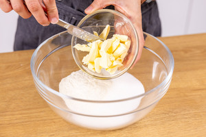Butter zum Mehl und Zucker geben