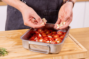 Knoblauch zu den Tomaten geben