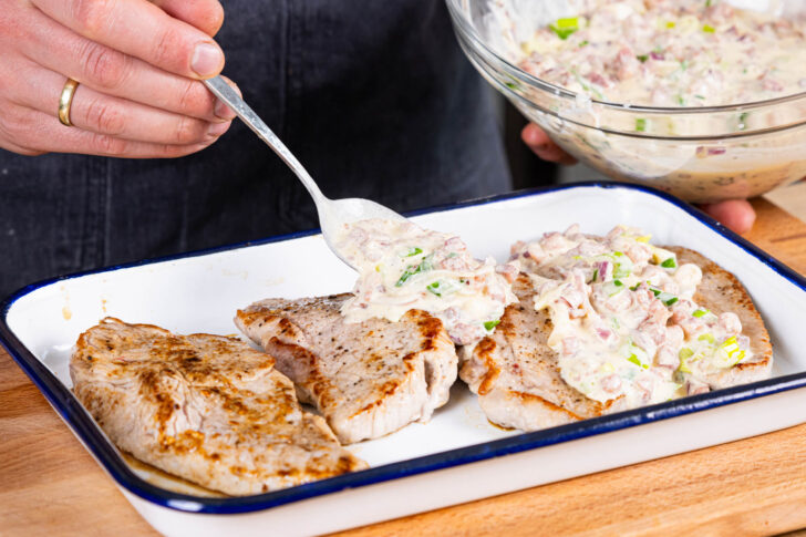 Flammkuchenmasse über Fleisch verteilen