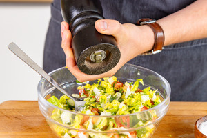 Salat mit Pfeffer würzen