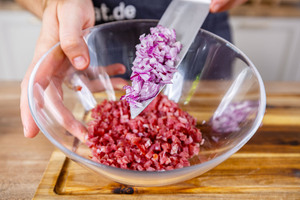 Zwiebel zu den Schinkenwürfeln geben