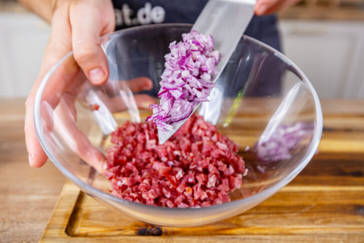 Zwiebel zu den Schinkenwürfeln geben