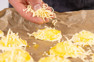 Flammkuchen-Taschen mit Käse bestreuen