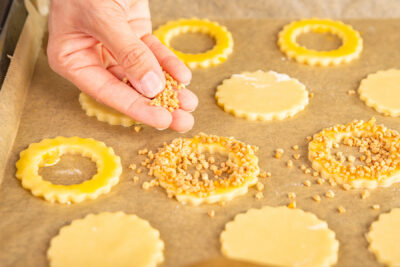 Haselnusskrokant über Plätzchen streuen