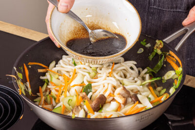 Sauce zu den gebratnenen Udon-Nudeln geben